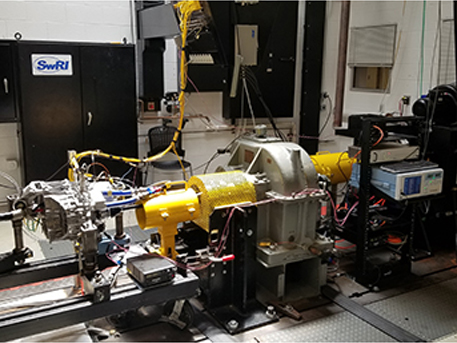 Tesla Model 3 drive unit mounted to a gearbox and dynamometer in a test cell