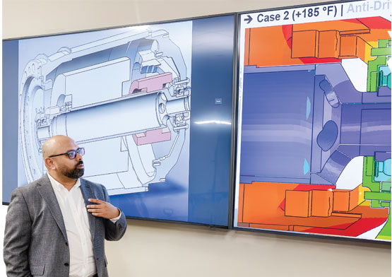 A man standing next to a screen, presenting the groups' findings.