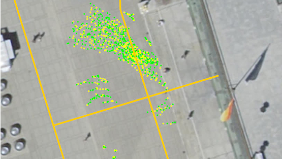 A world model output visualization, showing the crowd of pedestrians being tracked. It shows both their current positions (green dots) and their position history (yellow dots)