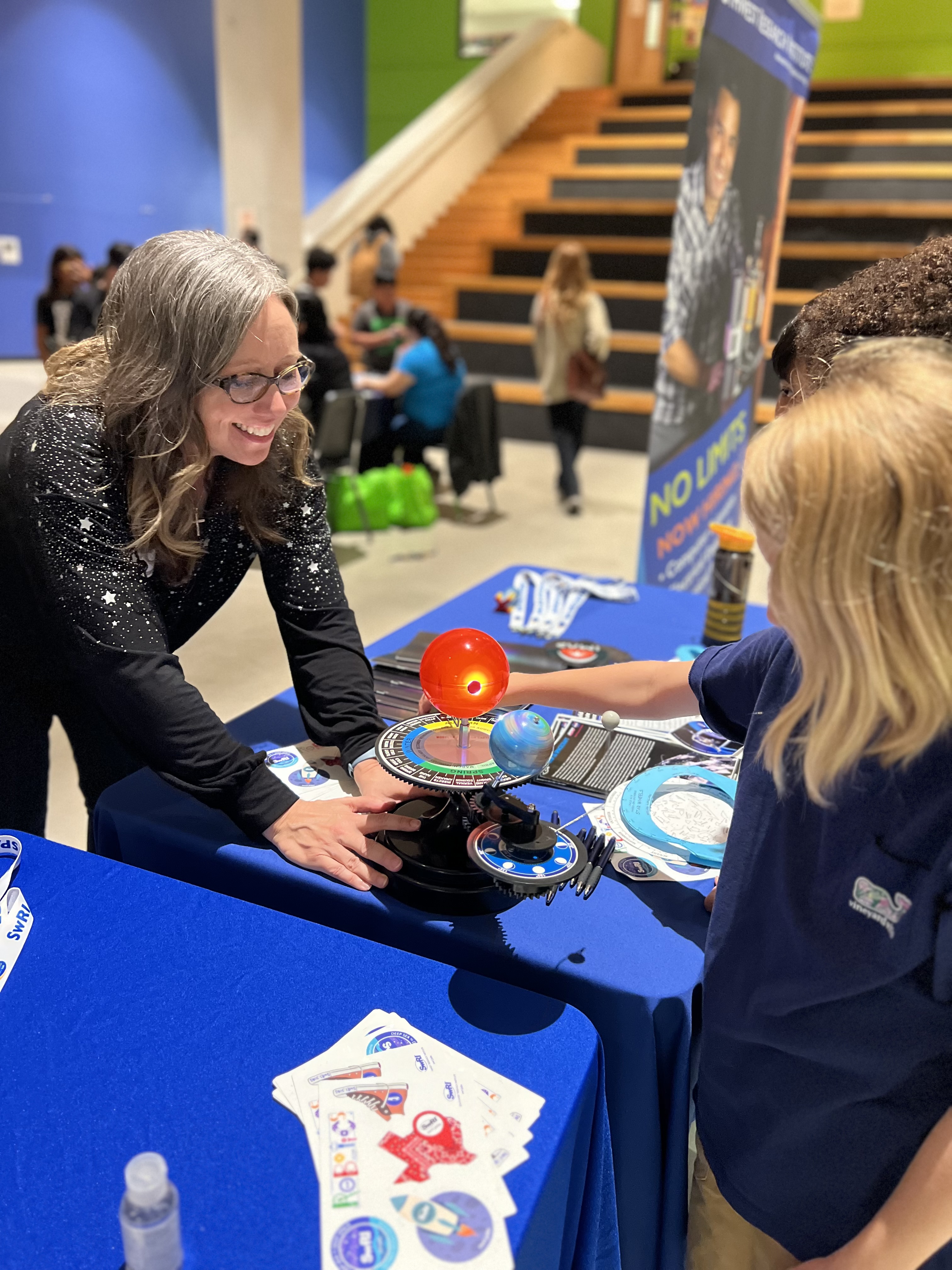 Figure 3. Amy Burgin explains how solar eclipses occur with students at a STEM event at SAISD’s Advanced Learning Academy, where students also participated in a conversation with astronauts on the International Space Station.