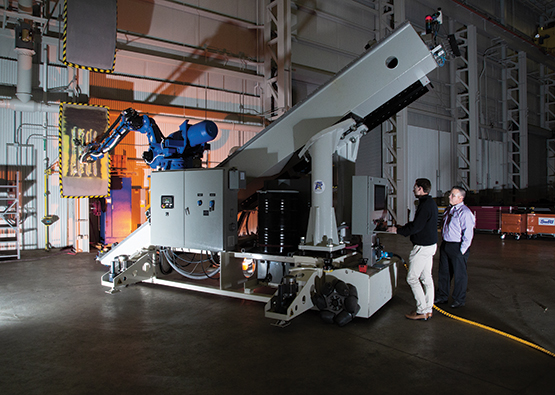 Two engineers standing next to the A5 Robotic System platform