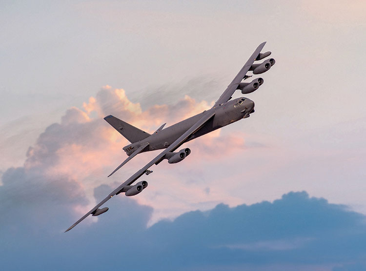 B-52 bomber in the air above blue clouds