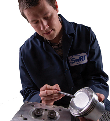 Researcher examines piston Researcher examines piston