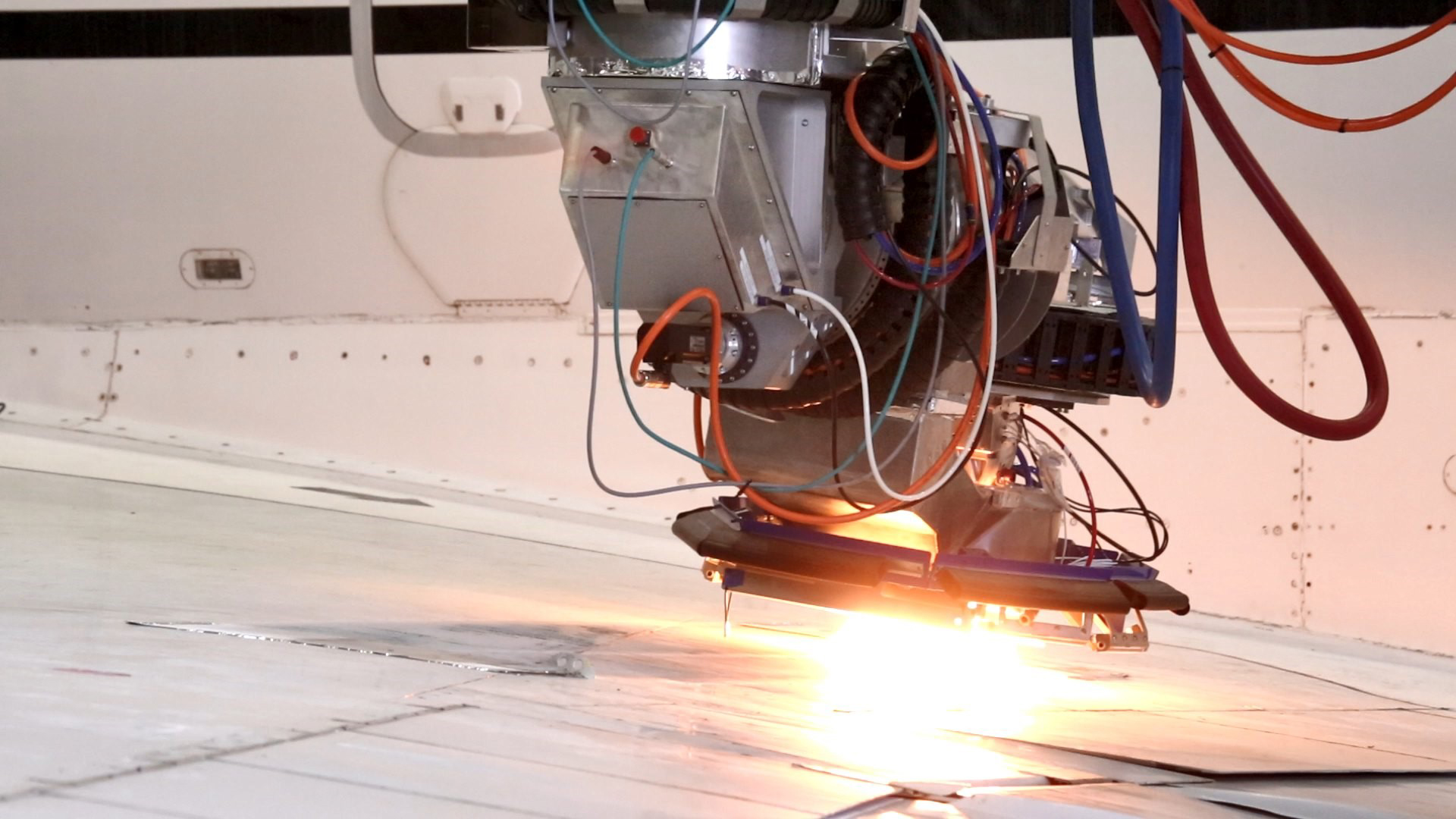 Close up view of CO2 laser evaporating paint from an aircraft