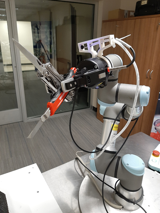 cobot system holding 2 knives in gripper