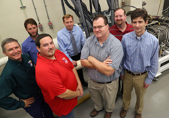 Seven men standing in front of high-inlet-temperature combustion system