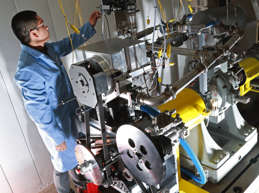 An engineer working on a single-cylinder research engine