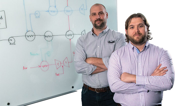 Aaron Rimpel and Dr. Owen Pryor standing in front of a whiteboard