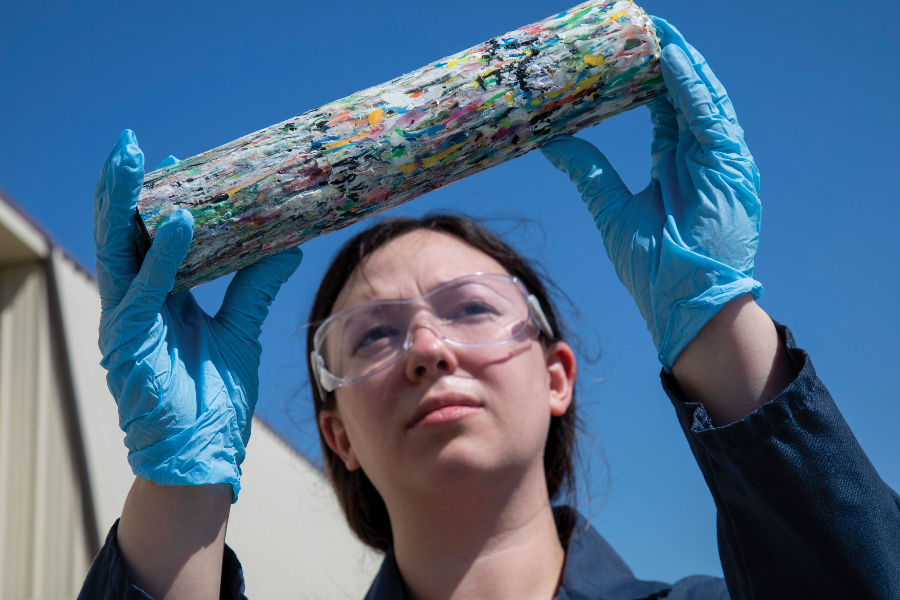 Engineer holding chemically recycled mixed plastics melted together into a cylinder