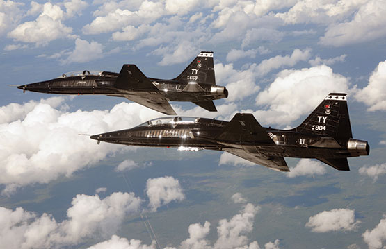 Two T-38 aircrafts in the sky with clouds