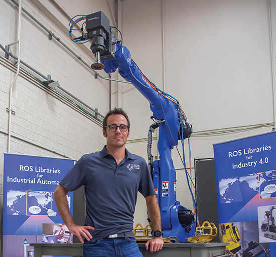 Matt Robinson in front of robotic arm in SwRI lab