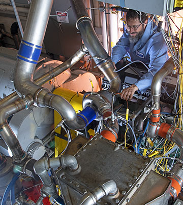 Technician monitoring a large diesel engine test stand