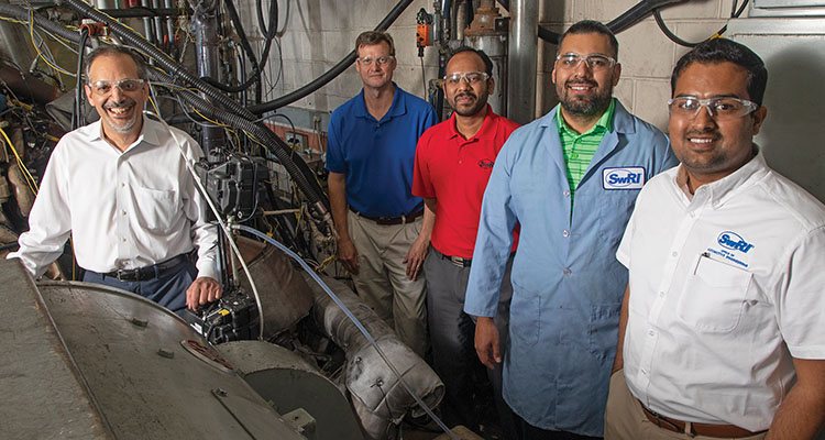 Members of the emissions program standing in an engine laboratory