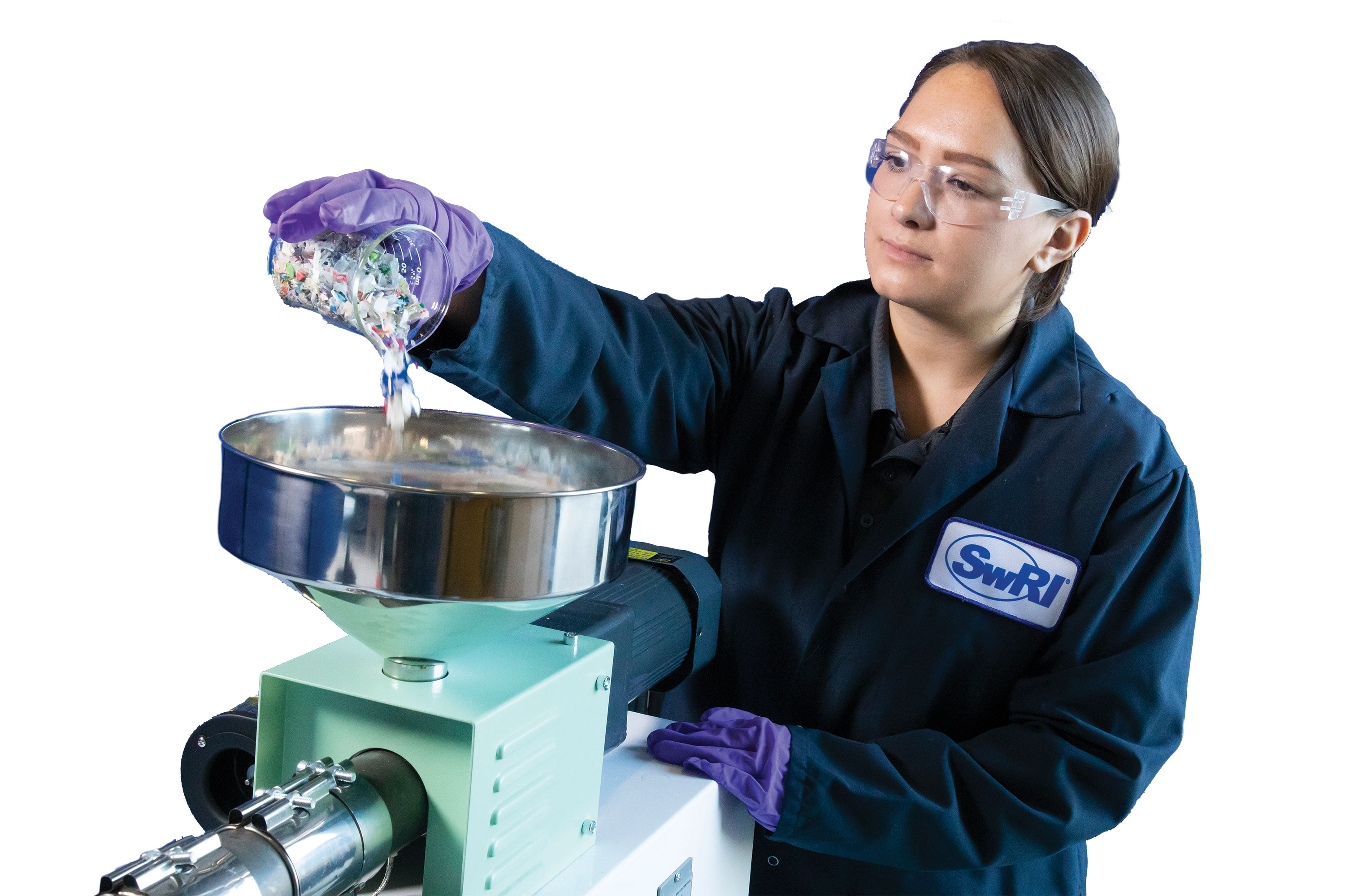 Engineer pouring plastic flakes into machine for heating and pressurizing 