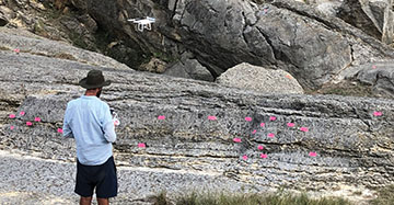 Drop flying over a rough outcrop with markers on it