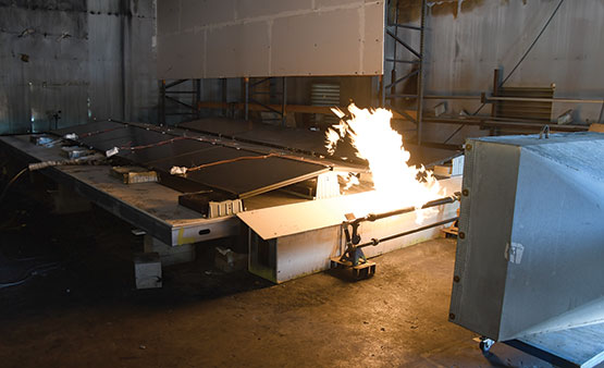 Flame spread between photovoltaic solar panels and roof materials.