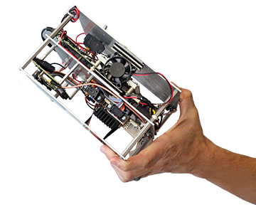 Hand holding a metal frame with electronic components inside