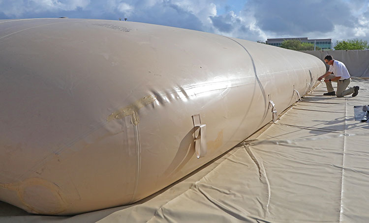 large cream-colored bladder filled up with a person kneeling next to it