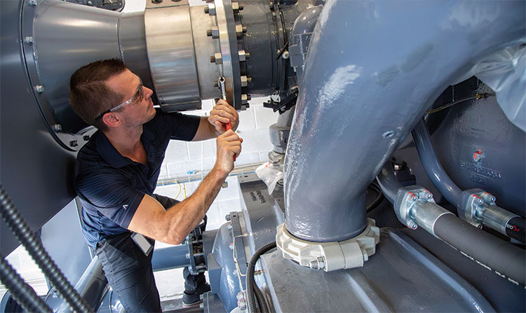A technician working on a powerful air compressor.