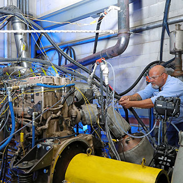 technician working on a heavy-duty engine in a laboratory