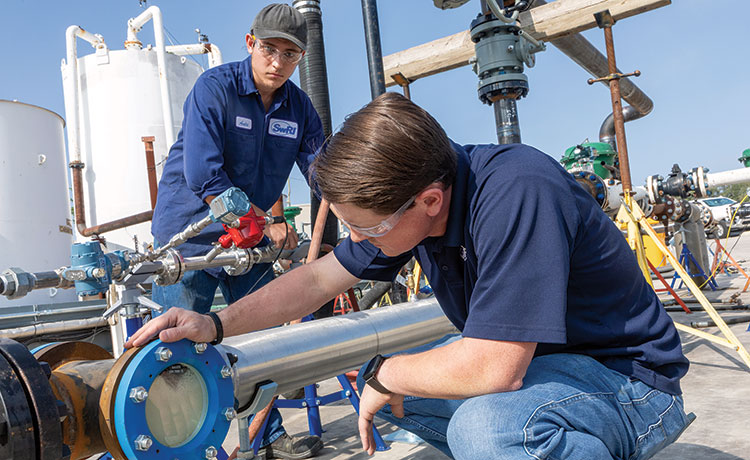 Two technicians working on the HVFL pipes.