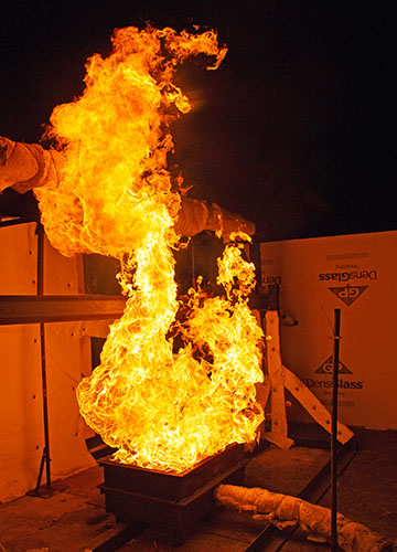 Fire test of an I-beam with yellow flames shooting into the air