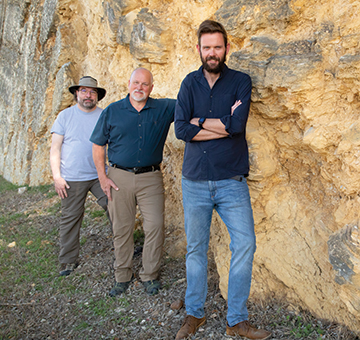 Dr. Kevin Smart, Dr. David Ferrill and Dr. Adam Cawood standing in front of a rock structure.