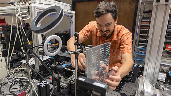 Engineer working with a laser-induced particle impact test machine