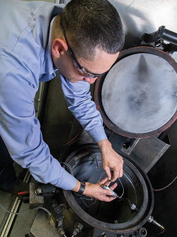 Staff Technician Mario Guillen installing a lithium-ion battery cell