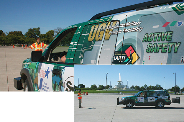 Man wearing safety visit standing in front of SwRI autonomous vehicle gesturing