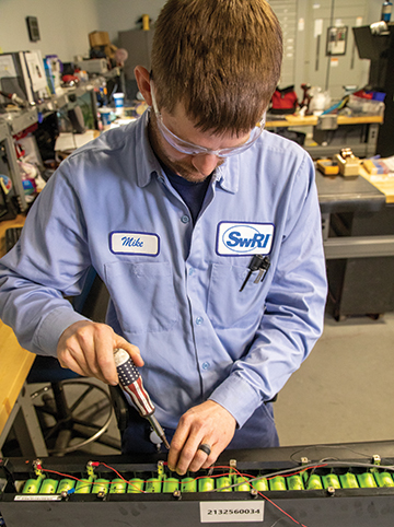 Senior Technician Mike Taylor instruments an EV battery module inside of a lab