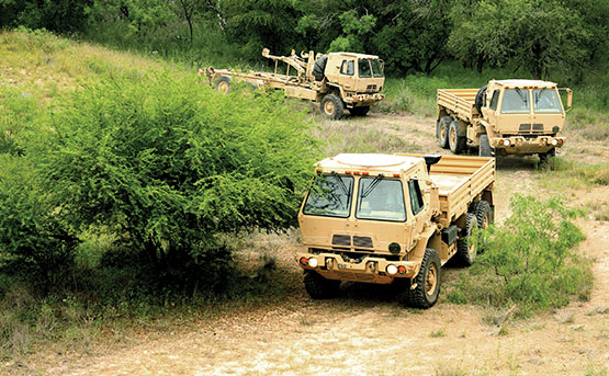 Military heavy truck convoy on a dirt road