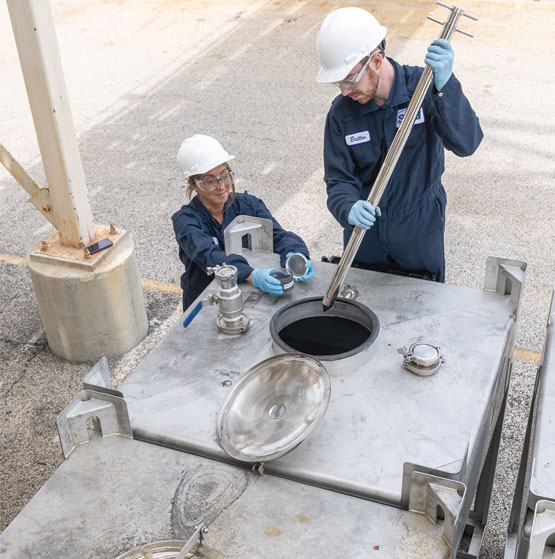 A scientist and an engineer examine graphite samples.