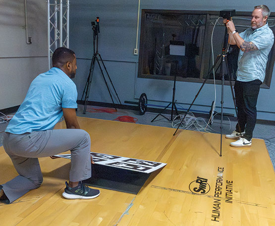 Two men demonstrate a camera system SwRI developed for edge processing for real-time 3D pose estimation