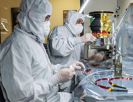 SwRI’s Jacob Friday (left) and Benjamin Rodriguez install red “remove before flight” protectors from the CoDICE instrument.