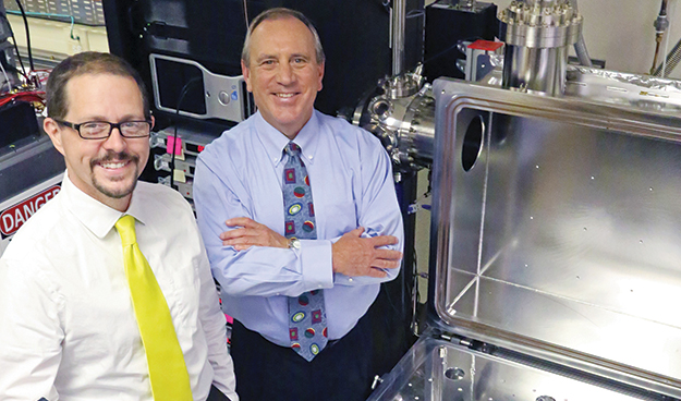 Dr. Kurt Retherford (left) and Dr. J. Hunter Waite standing side-by-side inside a laboratory