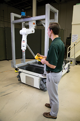 Engineer using a small-scale mobile manipulator system in a lab