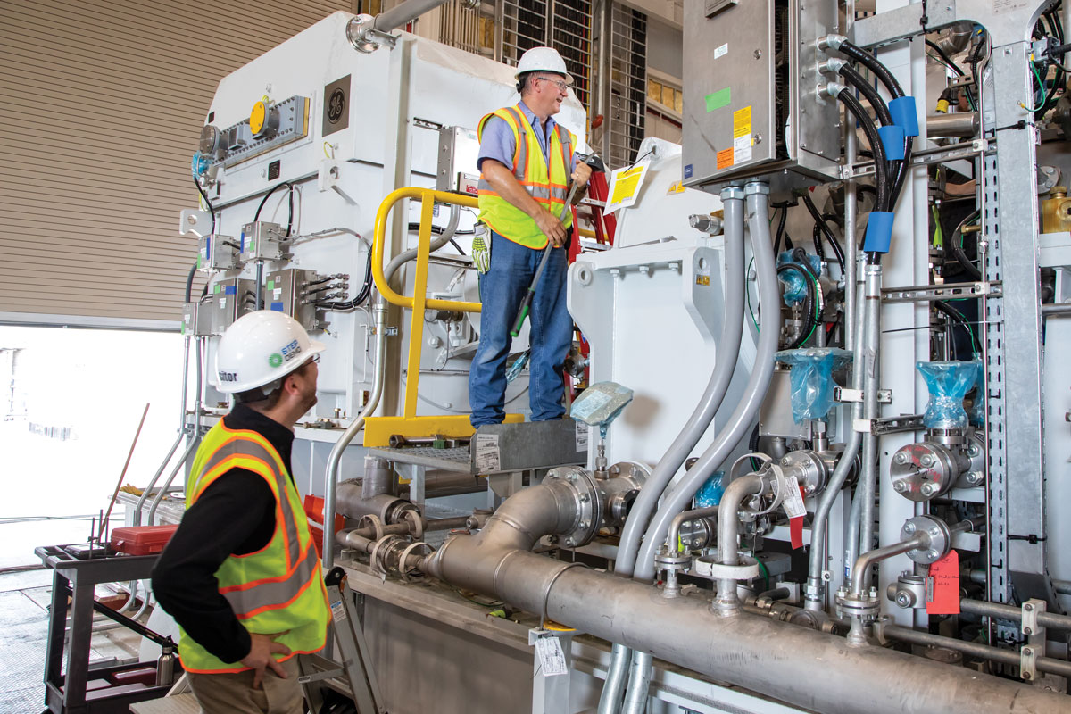 Two engineers in front of STEP main compressor