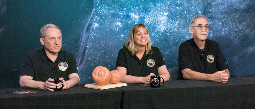 S. Alan Stern, Ph.D., Cathy Olkin, Ph.D., and John Spencer, Ph.D. sitting at a media event table