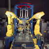 Two yellow robotic arms building components