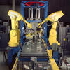 Two yellow robotic arms building components