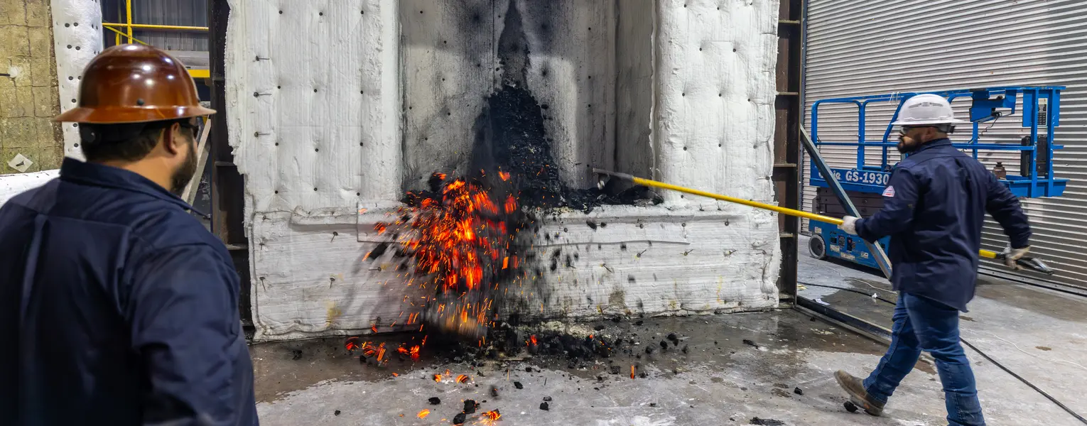 Two technicians doing a fire test on a laminated beam