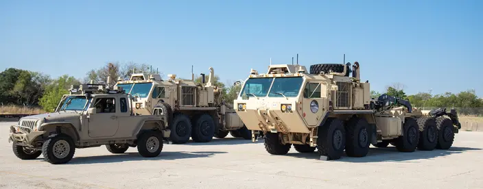 Two military vehicles on in a field 