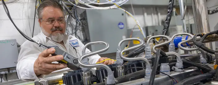 SwRI staff working on powertrain engine in SwRI lab