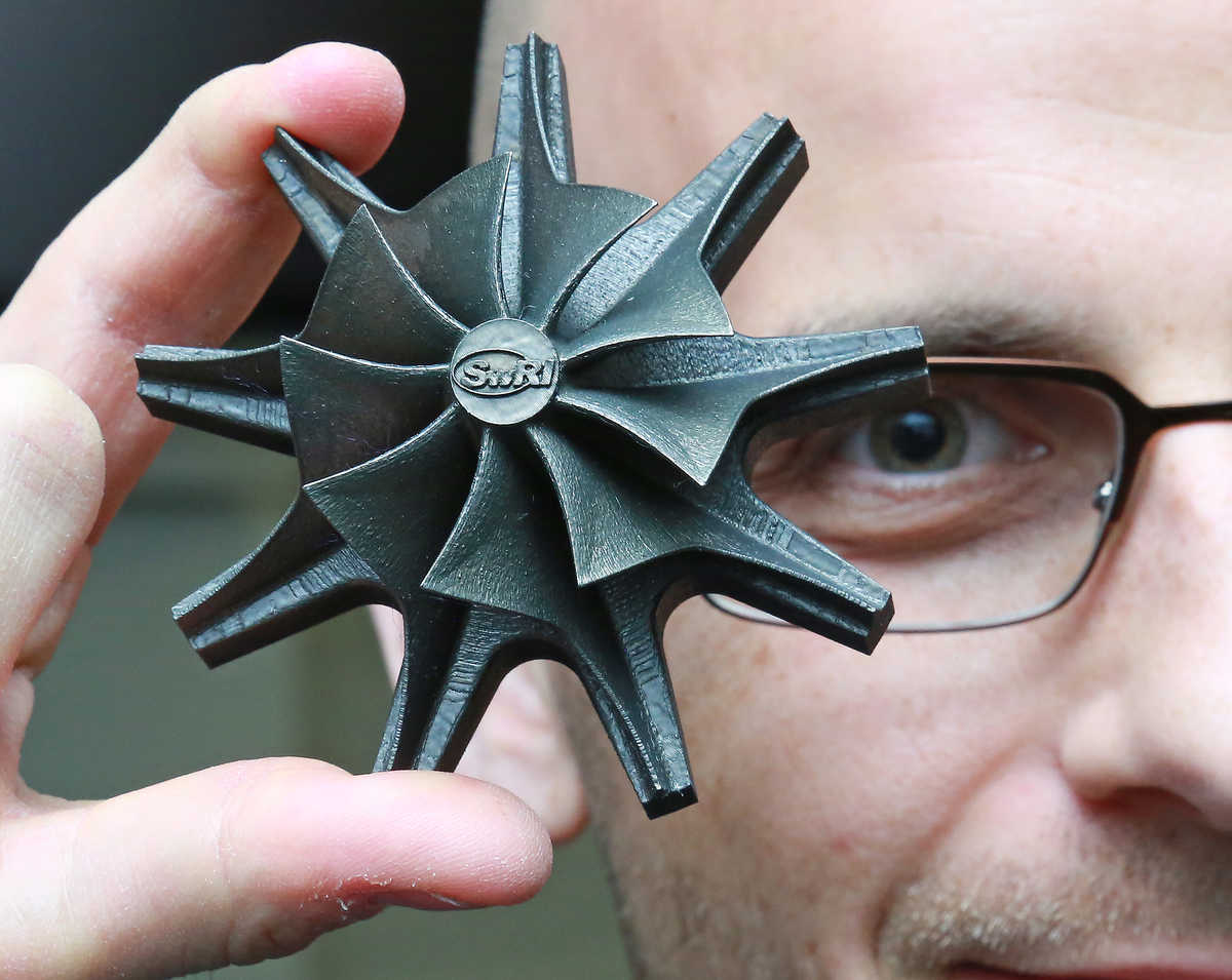 Grant Musgrove holds up an impeller made through the additive manufacturing process.