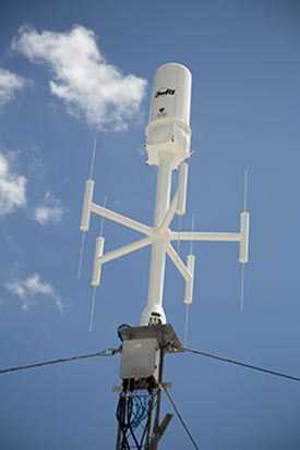 White antenna with blue sky and clouds in the background