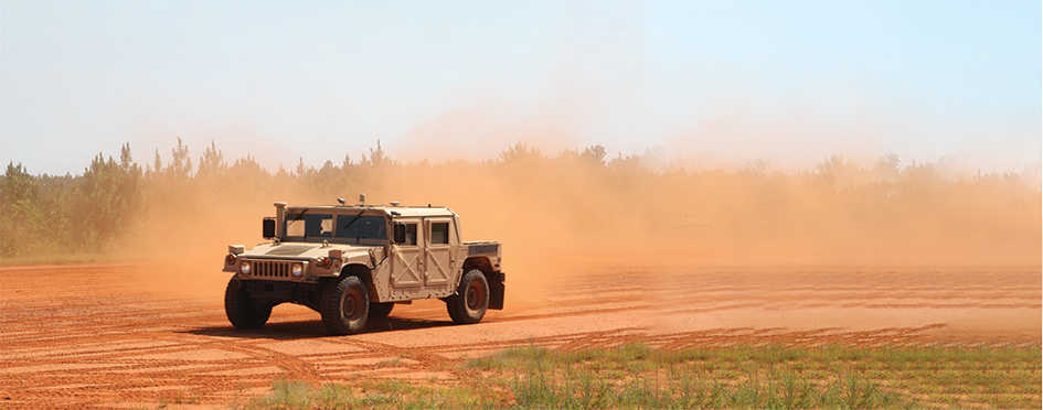 U.S. Army High Mobility Multipurpose Wheeled Vehicle (humvee) driving down dirt road