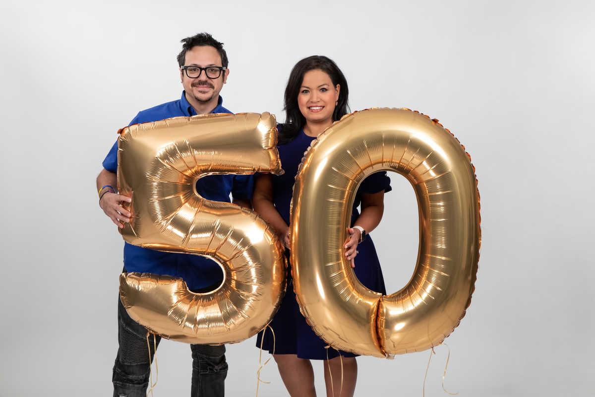 Bryan Ortiz and Lisa Peña holding gold 5 0 balloons