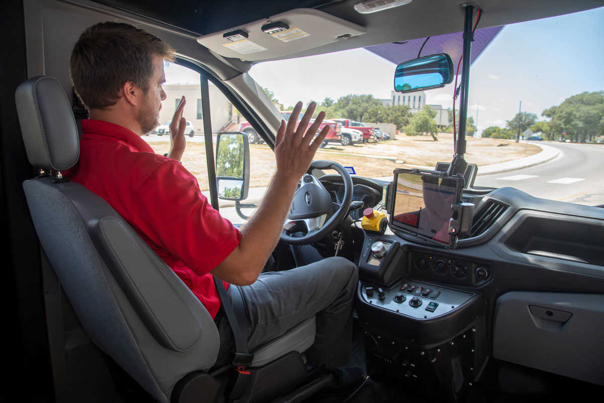 Vehicle operator demonstrating the self-driving capability of the SwRI automated shuttle