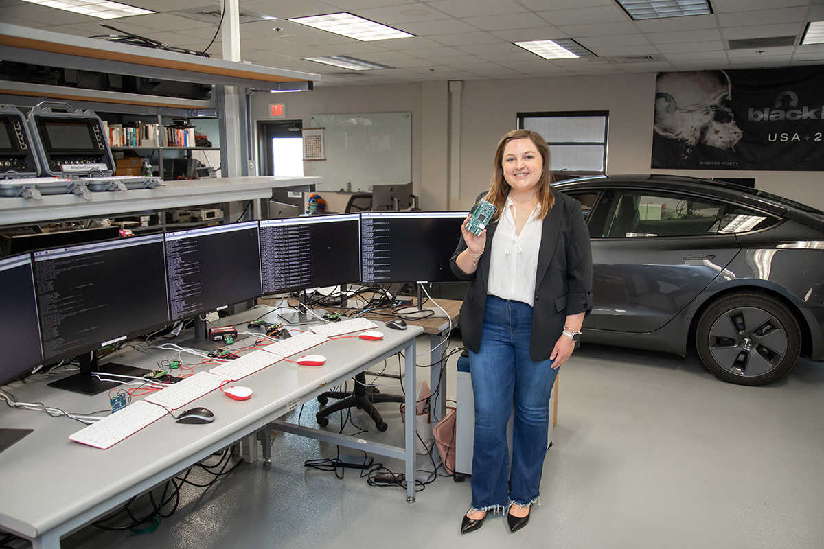 Maggie Shipman standing in computer lab holing a can bus network interface
